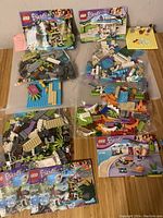 Four bags of LEGO pieces grouped by set with four instruction booklets visible; some small pieces missing as noted by seller.