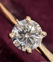 Top-down close-up view of round brilliant diamond set in six-prong 10K yellow gold mounting