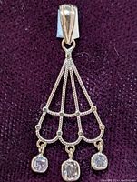 Front view of the 14K gold pendant showing pink cushion-cut diamonds and twisted gold loops