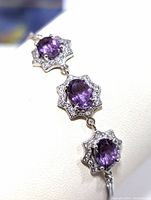 Close-up photo of the sterling silver bracelet showing three linked segments with purple amethyst stones surrounded by cubic zirconia accents.