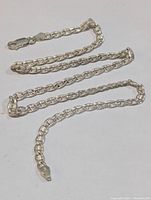 Silver chain necklace laid out showing full length.