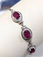 Close up image of the sterling silver bracelet showing the ruby stones and CZ halos.
