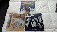 Three vinyl LP albums laid out flat showing front covers: The Police, Rainbow, Moody Blues.