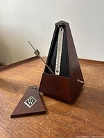 Antique Wittner metronome with wooden case removed showing metal pendulum and sliding weight.