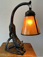 Front view of entire lamp showing stretching cat figure and illuminated mica shade