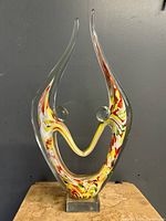 Front view of signed Murano glass sculpture with abstract lovers design in yellow, red, and white glass swirls.