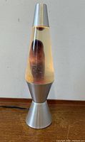 Full view of the vintage lava lamp with clear liquid and purple wax inside, silver metallic base and cap visible.