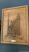 Frontal photo of raised wood art showing detailed depiction of Flat Iron Building, CN Tower, streetcar, and signature plaque.