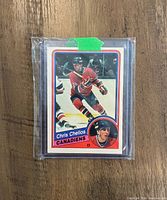 Photo of Chris Chelios rookie hockey card encased in protective sleeve with green tape seal.