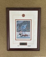 Framed signed print showing the moment of Paul Henderson's goal in 1972 hockey series with Canada vs Russia. The print is professionally matted and framed in a dark wood frame.