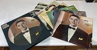Photo showing the Frank Sinatra 5 LP box set and five vinyl record sleeves arranged on a table. Covers feature images of Frank Sinatra in tuxedo with yellow pocket square.
