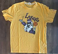 Yellow Los Angeles Lakers t-shirt with a Grateful Dead skeleton basketball player graphic in purple and orange.