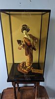 Front view of Geisha statue in glass showcase