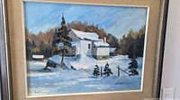 Front view of framed oil painting showing snowy farmhouse and trees with blue sky background.