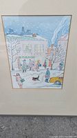 Frontal view of framed watercolour painting showing snowy street scene