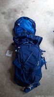 Full view of the blue Gregory Zulu 40 hiking backpack laid flat showing top lid and front design.