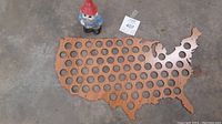 Photo of wooden US map quarter display with gnome piggy bank from distance showing full items and layout.