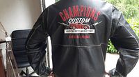 Back view showing large embroidered design with 'CHAMPIONS CUSTOM SPEED SHOP RADIATOR SPRINGS' text and a red classic car.