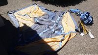 North Face Peregrine tent fabric laid out flat on ground, showing blue and yellow nylon material.