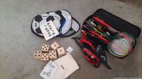 Mixed yard games including badminton set rackets and soccer throw targets with balls in soft bags.
