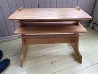 Solid wood child-sized table with three shelves and curved stable legs, natural wood finish.