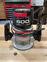 Front view of Craftsman router showing black and silver body with red lock/unlock shaft adjustment and black handles.