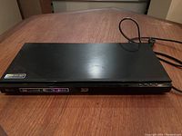 Top view of LG Blu-Ray DVD player showing the smooth black surface with stickers indicating 3D support and BD-Live compatibility.