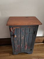 Front view of rustic antique wood cabinet with natural wood top and distressed blue painted body, door closed