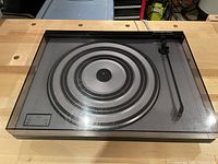 Top view with dust cover closed, showing platter and tonearm.