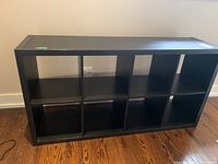 Front view of black manufactured wood bookcase with eight sections