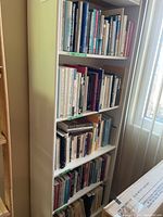 Photo of bookshelf with multiple shelves filled with books related to self help, mental health, psychology and women's issues, showing spines of books with various titles.
