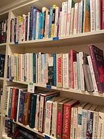 Shelf of assorted medical and health-related books, both hard and soft cover, well organized on bookshelf.