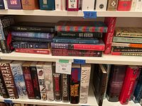 Shelf displaying Stephen King fiction books including hardcover and paperback editions along with other fiction titles