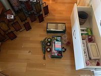 Overview of candles and candle accessories including taper candles, small candles, and various holders in a drawer and on floor