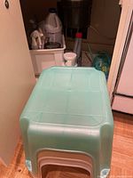 Three nested Rubbermaid plastic step stools in light turquoise and beige