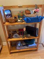 Wooden shelving holding multiple decorative items including baskets, crystals, wind chimes, and trays.