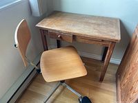 Desk and chair viewed from front against wall