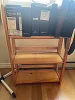 Front view of the wooden bookshelf loaded with various boxed items to illustrate shelf size and use