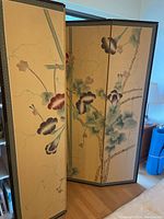 Front view of 4-panel folding screen showing floral artwork on painted paper surface and wood frame.
