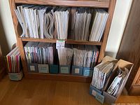Magazines sorted and stored upright in wooden shelves and magazine holders labeled by title.
