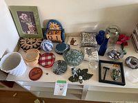 Overview of assorted items on tabletop including decor, coasters, and glassware