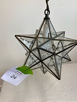 Star-shaped glass pendant lamp hanging to show form and chain