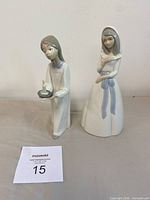 Front view of both porcelain figurines standing upright