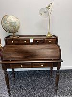 Front view of roll-top desk closed with lamp and globe displayed