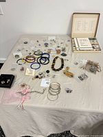 Overview of entire lot on table showing jewelry pieces and rocks & minerals kit