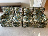 Front view of the floral pattern casual couch with three seat and three back cushions, showing the floral upholstery and worn condition.
