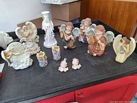 Photo showing all angel figurines, candelholders, cherub ornaments arranged on table