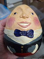 Close-up front image of Humpty Dumpty figurine showing detailed face, bow tie, and vest.