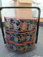 Front and side view of lacquered 3 tiered wedding box with floral and bird hand painted designs