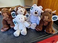 Lot of 6 Mary Meyer plush animals displayed on a black surface including two brown bison, a white lamb, a white bear, and a brown monkey all tagged.